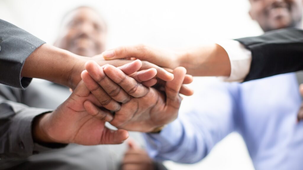 Hands join together as union