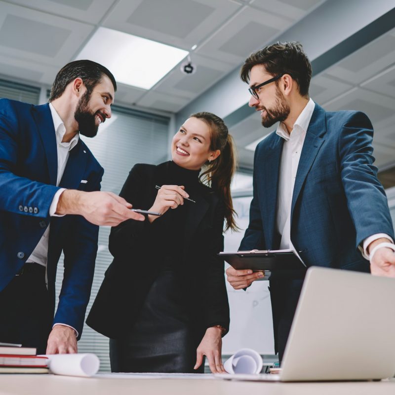 Smiling female manager working together with colleagues in modern office